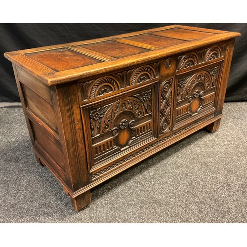 90 - An 18th century style carved oak coffee / blanket chest, four-panel hinged top, carved front, block ... 