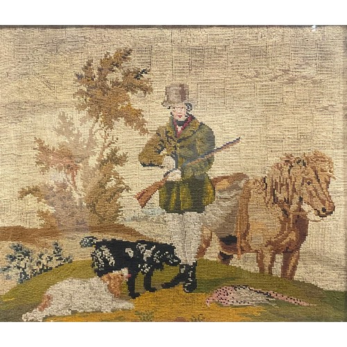 2130 - An 19th century woolwork picture, worked in coloured wools with a sportsman hunter alongside his hor... 