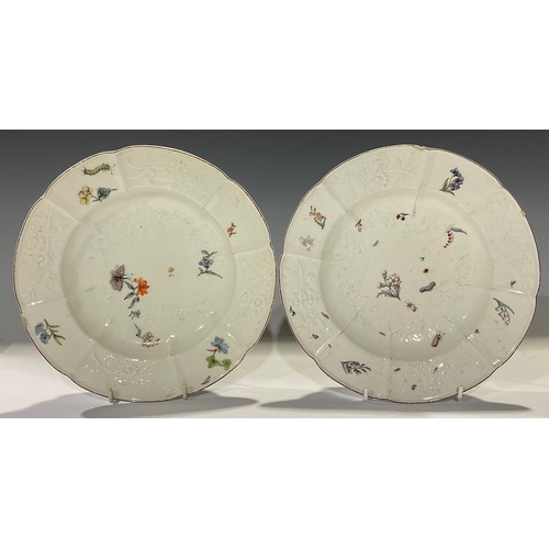 52 - A pair of Chelsea shaped circular plates, moulded with flowers and painted in polychrome with insect... 