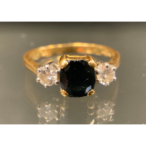 1033 - A diamond and sapphire three stone ring, central rectangular cut deep blue sapphire approx.1.50ct, b... 