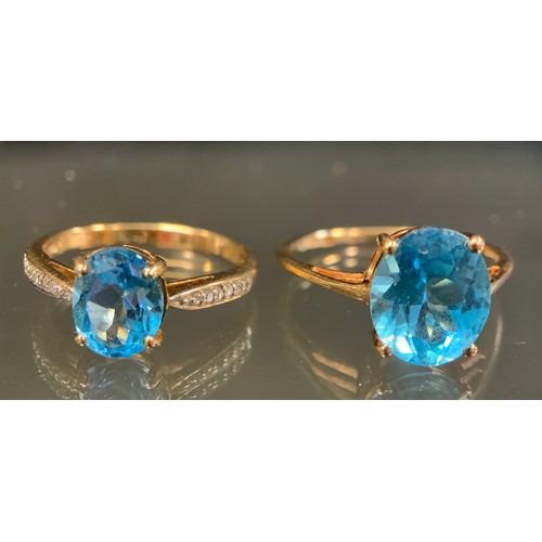 438 - A 9ct gold vibrant Swiss blue stone and diamond dress ring, oval blue stone set between six stoned d... 