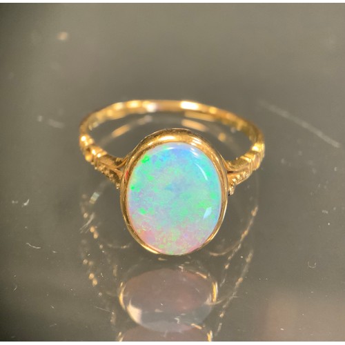 445 - An opal cabochon doublet ring, measuring approx 10.80mm x 8.89mm x 2.94mm, with vibrant green blue a... 