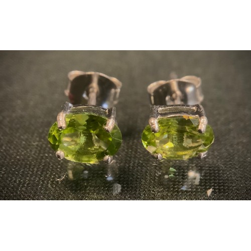 472 - A pair of oval peridot stud earrings, silver mounts, 1.5g gross