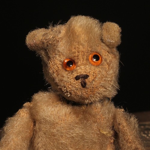 84 - An early 20th century jointed golden mohair miniature teddy bear, amber and black glass eyes, brown ... 