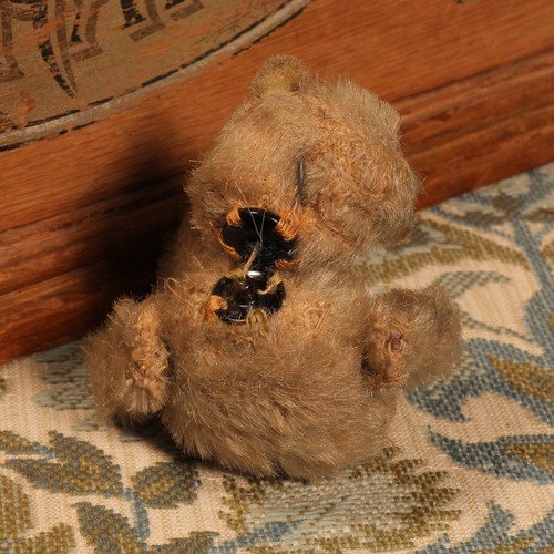 84 - An early 20th century jointed golden mohair miniature teddy bear, amber and black glass eyes, brown ... 