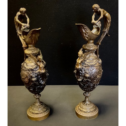 28 - A pair of Italianate baluster-form bronzed-metal ewers, in the classical taste, cast with Nymph hand... 