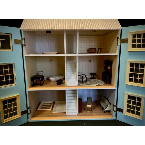 51 - A 20th century three storey dolls house with fitted interior including conforming furniture, etc.