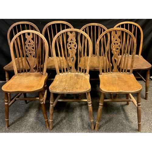 59 - A harlequin set of seven elm spindle-back chairs, comprised of three with wheel splat, and two pairs... 