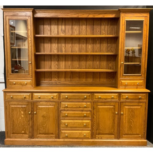 105 - A large oak dresser, break-front centre top section, with out-swept cornice, above three tiers of pl... 