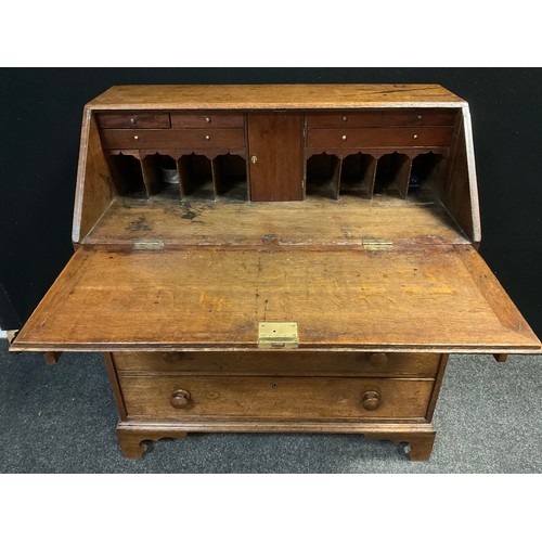 116 - A George III oak bureau, hinged fall top enclosing fitted interior, over four graduated long drawers... 