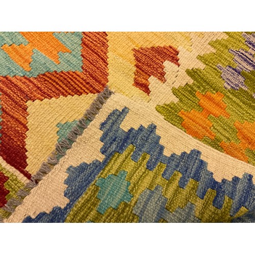 148A - A Turkish Anatolian Kilim, knotted with a geometric pattern in tones of red, blue, green, and cream,... 