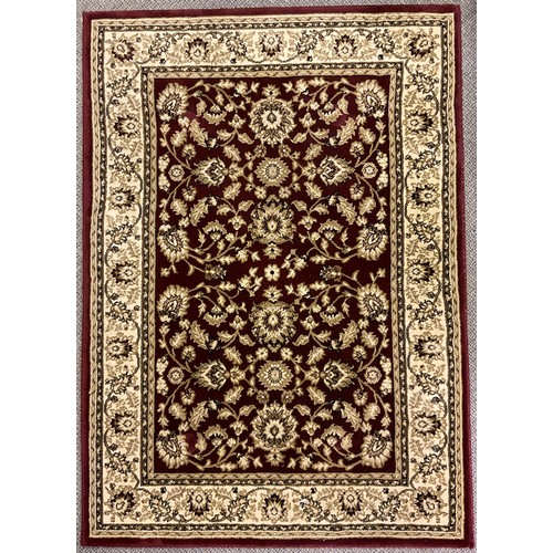 332 - A Middle Eastern style rug / carpet, knotted in tones of red, dark blue, brown, and cream, 164cm x 8... 