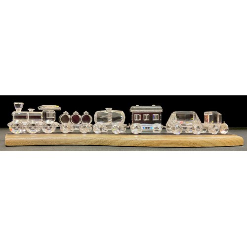 396 - Swarovski crystal - a train set comprising locomotive and five carriages, wooden train track stand