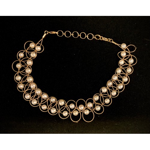 515 - A cultured pearl and yellow metal choker necklace, fine wire lattice adorned with creamy white cultu... 