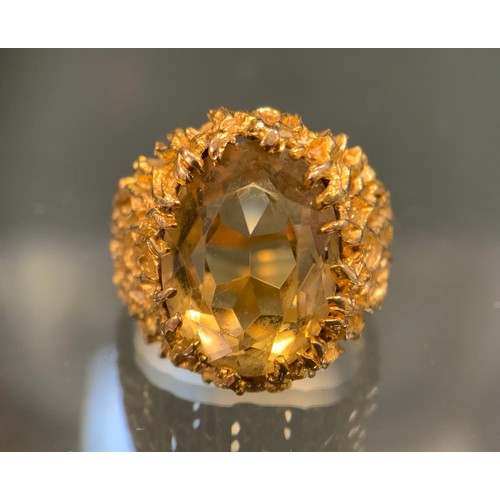 568 - A citrine signet ring, volcanic effect textured mount surrounding a pale oval citrine, 9ct gold shan... 