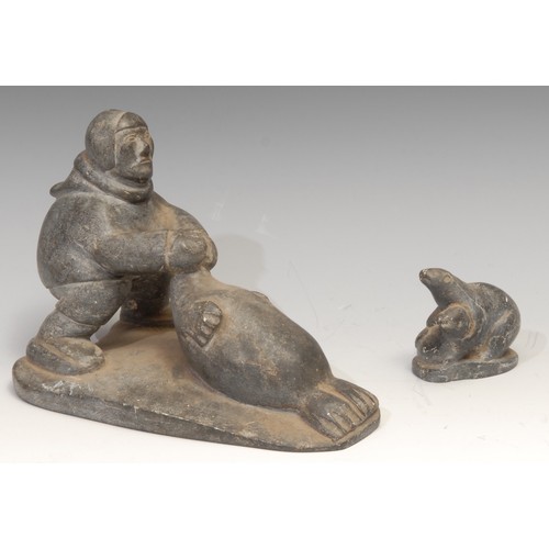 15 - An Inuit soapstone carving, of a hunter and a seal, 21cm long, label for Canadian Inuit Art, mid 20t... 