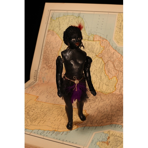 123 - An early 20th century black composition jointed doll, painted features, black flock type hair, 20cm ... 