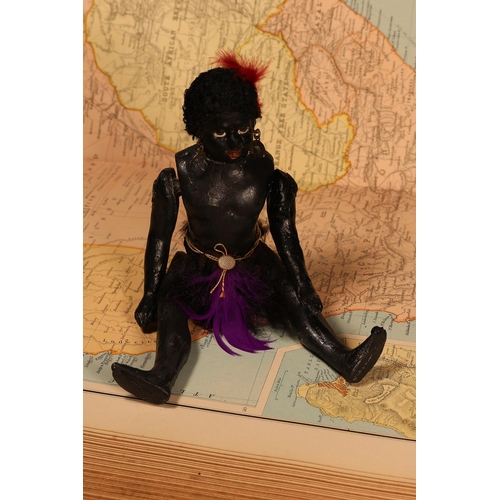 123 - An early 20th century black composition jointed doll, painted features, black flock type hair, 20cm ... 