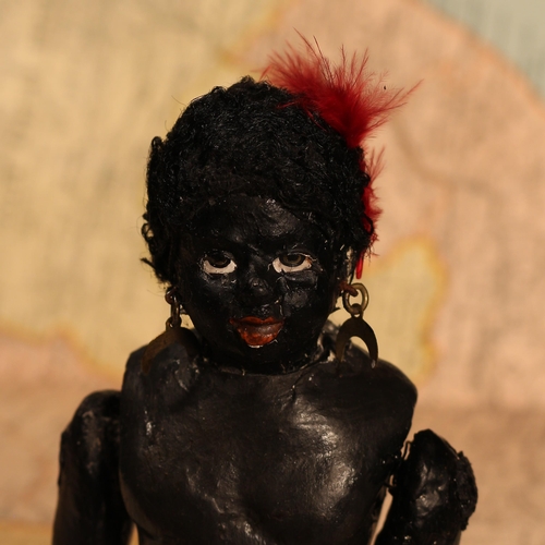 123 - An early 20th century black composition jointed doll, painted features, black flock type hair, 20cm ... 