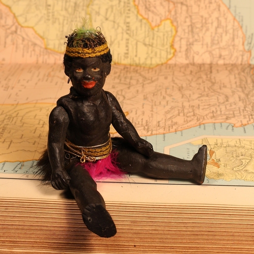 124 - An early 20th century black composition jointed doll, painted features, black flock type hair, 15cm ... 