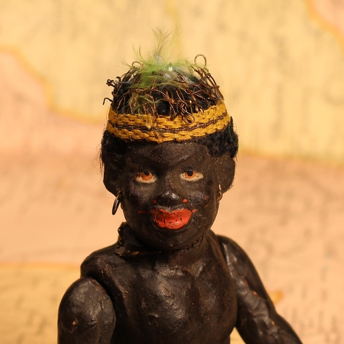 124 - An early 20th century black composition jointed doll, painted features, black flock type hair, 15cm ... 