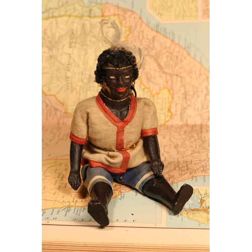 125 - An early 20th century black composition jointed doll, painted features, black flock type hair, 20cm ... 