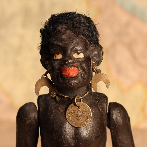 126 - An early 20th century black composition jointed doll, painted features, black flock type hair, 18cm ... 