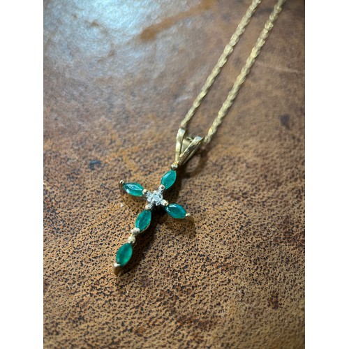 638 - A 9ct gold, emerald and diamond crucifix pendant, the central round brilliant cut stone flanked by f... 