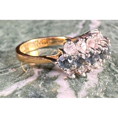 646 - A gold coloured metal cluster dress ring, set with a row of blue coloured stones flanked by two row ... 