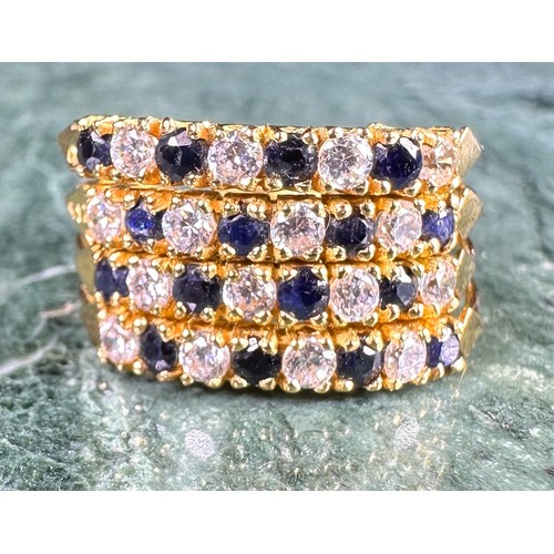 646 - A gold coloured metal cluster dress ring, set with a row of blue coloured stones flanked by two row ... 