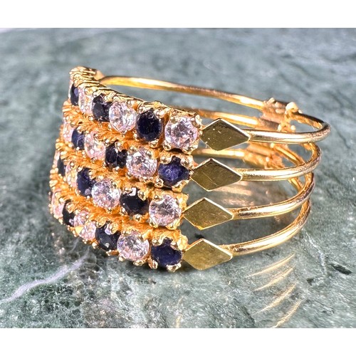 646 - A gold coloured metal cluster dress ring, set with a row of blue coloured stones flanked by two row ... 