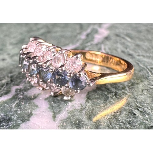 646 - A gold coloured metal cluster dress ring, set with a row of blue coloured stones flanked by two row ... 