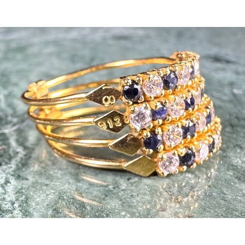 646 - A gold coloured metal cluster dress ring, set with a row of blue coloured stones flanked by two row ... 