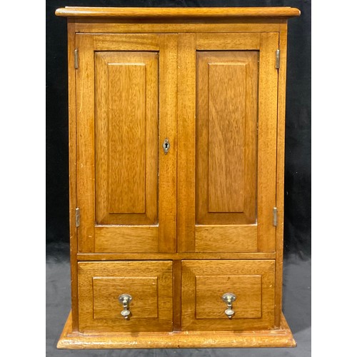 697 - A mahogany collector's cupboard, the pair of fielded doors above two drawers, brass drop handles, 57... 