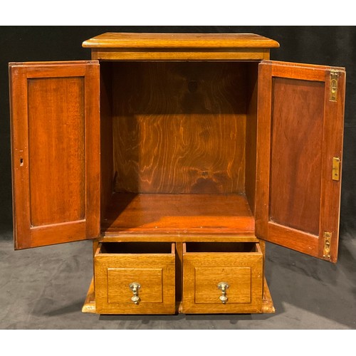 697 - A mahogany collector's cupboard, the pair of fielded doors above two drawers, brass drop handles, 57... 