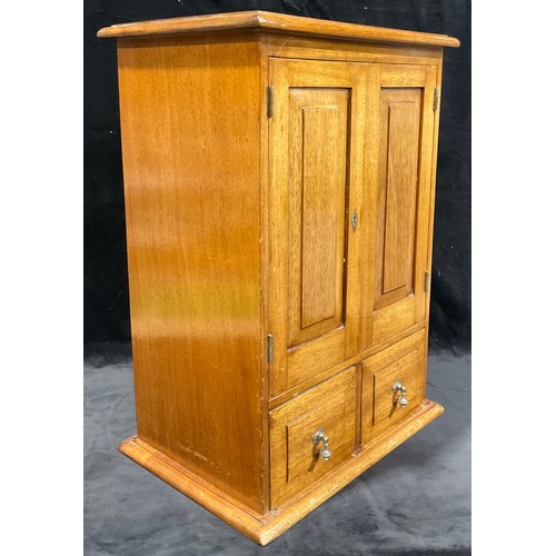 697 - A mahogany collector's cupboard, the pair of fielded doors above two drawers, brass drop handles, 57... 