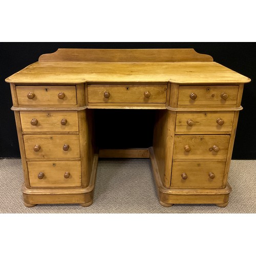 28 - A pine pedestal desk, quarter-galleried top with break-centre shaped front and three drawers to frie... 