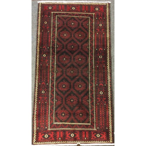 29 - A North East Persian Meshed Belouch rug / carpet, knotted with a geometric field, within a margins o... 