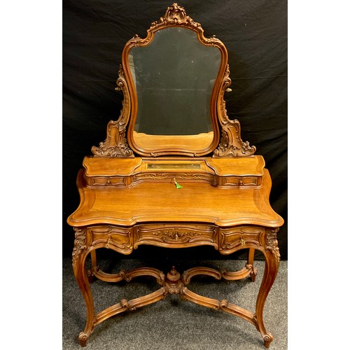 47 - A Baroque Louis XV style carved walnut dressing table, shaped mirror with carved cresting and suppor... 