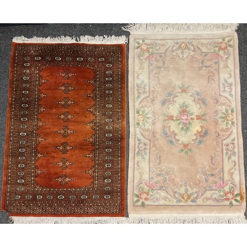 67 - A Middle Eastern style rug in tones of umber, brown, and black, 153cm x 97cm;  a Chinese rug, in sof... 