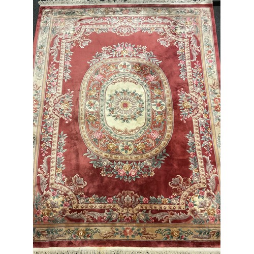 81 - An impressive Chinese deep-pile wool carpet, in subdued tones of red, green, pink, and cream, 350cm ... 