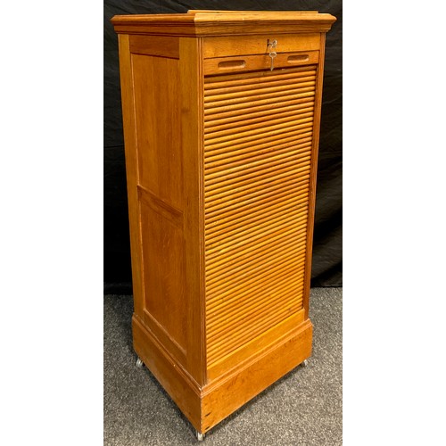 99 - A golden oak music cabinet, tambour front enclosing eight music sheet drawers, lift-up ‘lectern’ sta... 