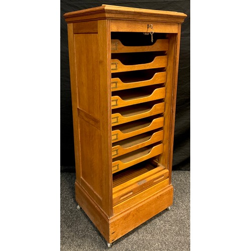 99 - A golden oak music cabinet, tambour front enclosing eight music sheet drawers, lift-up ‘lectern’ sta... 