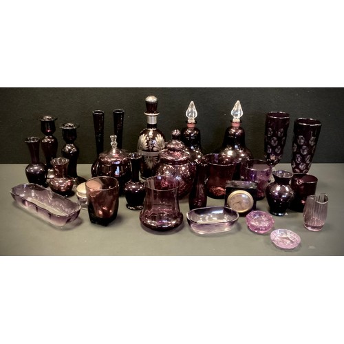 122 - A quantity of amethyst glass including; a pair of candlesticks, 20cm high, jars with stoppers, a dec... 