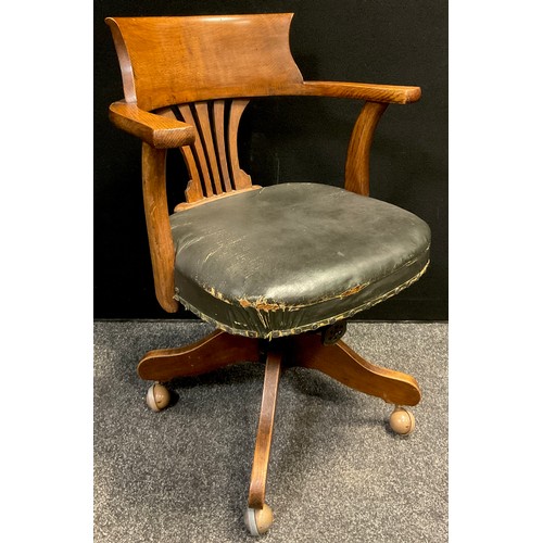 256 - An early 20th century oak swivel desk chair, 61.5cm wide.