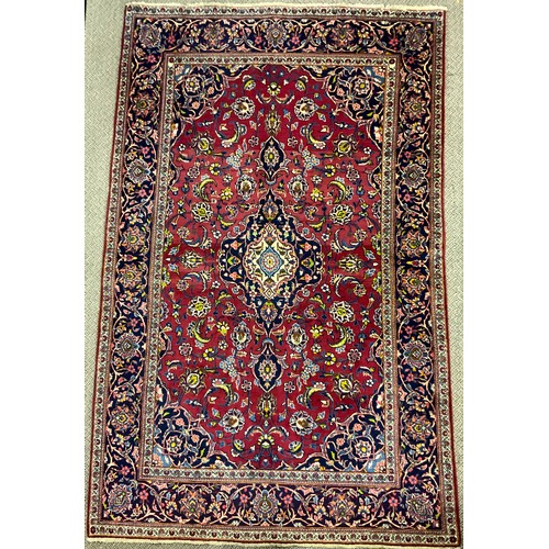 310 - A Central Persian Kashan rug / carpet, knotted in rich tones of red, blue, deep indigo, green, and c... 