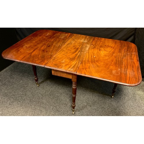 311 - A George III mahogany drop-leaf dining table, rounded rectangular top, turned legs, brass casters, 7... 