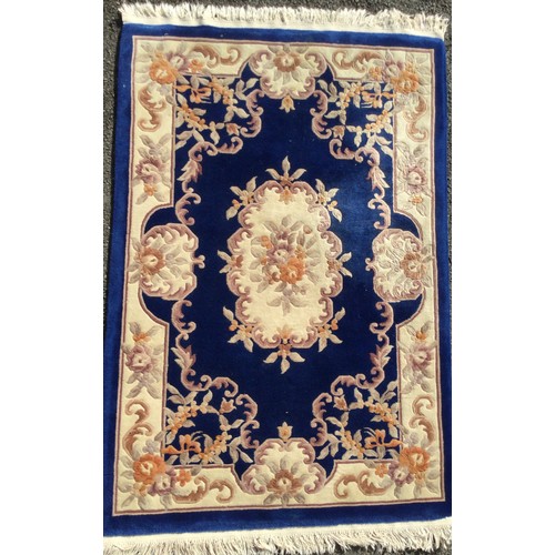 315 - A Chinese deep pile woollen rug / carpet, in deep blue, pink, and cream, 187cm x 126cm.