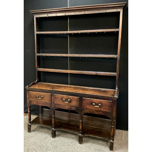 320 - An 18th century style Welsh oak dresser, of small proportions, swept cornice, plate-rack top with th... 