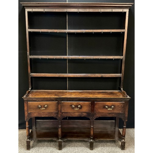 320 - An 18th century style Welsh oak dresser, of small proportions, swept cornice, plate-rack top with th... 